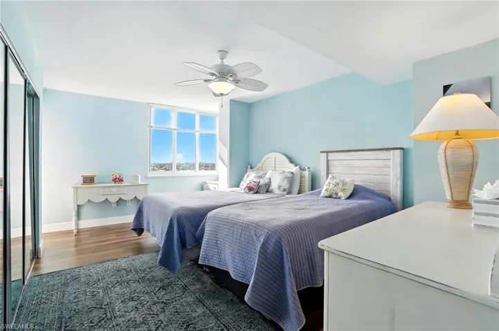 Bedroom with wood finished floors and a ceiling fan - Virtually Edited Image