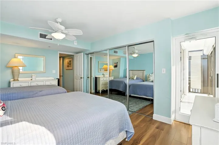 Bedroom with wood finished floors, a closet, and a ceiling fan - Virtually Edited Image