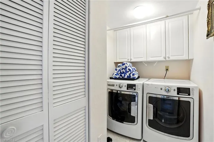 Laundry area with washing machine and dryer and cabinet space - Virtually Edited Image