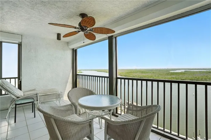 Balcony featuring Bay water view and a ceiling fan - Virtually Edited Image