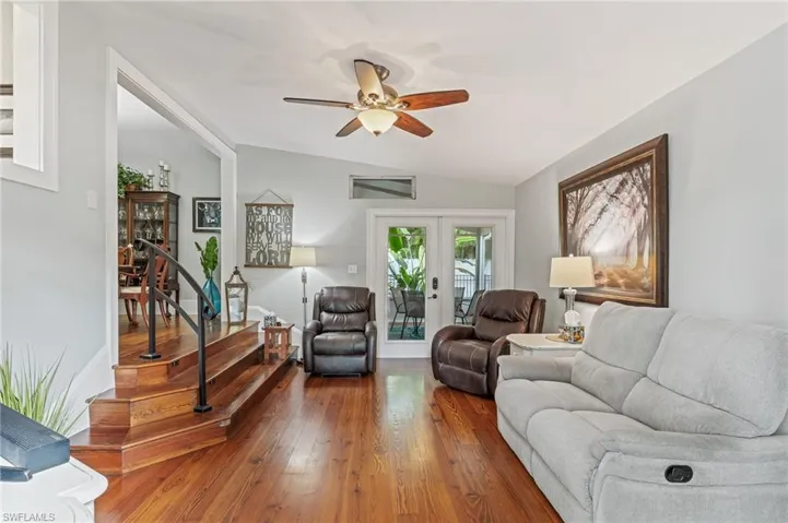 Living area featuring wood-type flooring, french doors, a ceiling fan, and lofted ceiling