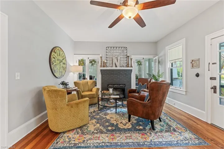 Living area with wood finished floors, a fireplace, and ceiling fan