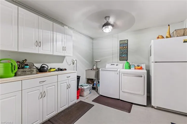 Laundry room featuring washer and dryer, ceiling fan, and cabinet space