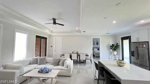Living room featuring ornamental molding, recessed lighting, and a ceiling fan