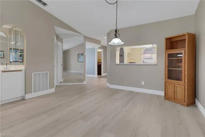 Living & dining area featuring vaulted ceiling, wet bar area.
