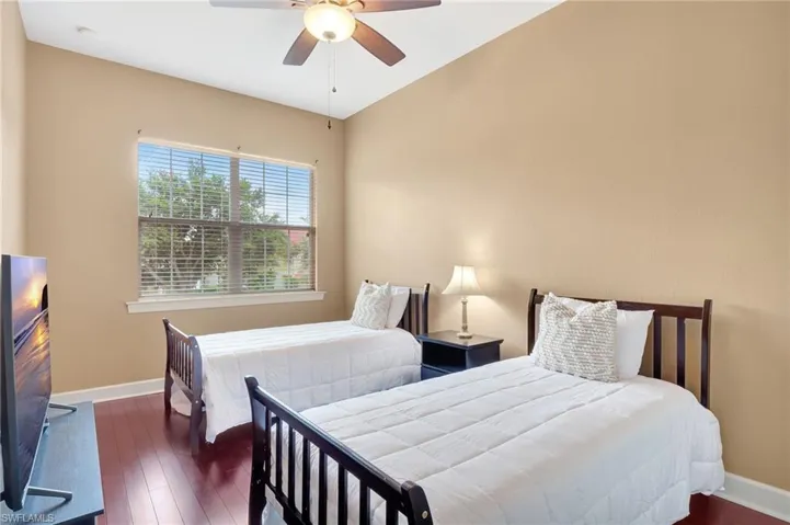 Bedroom with ceiling fan and dark wood-type flooring