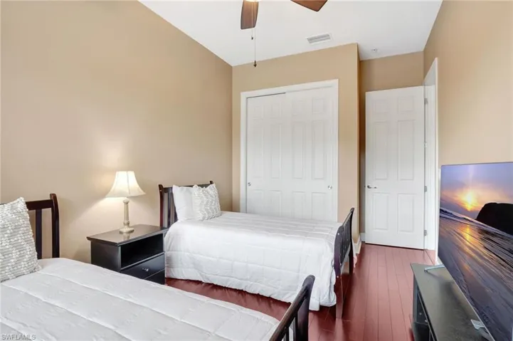 Bedroom featuring a closet, ceiling fan, and dark hardwood / wood-style flooring