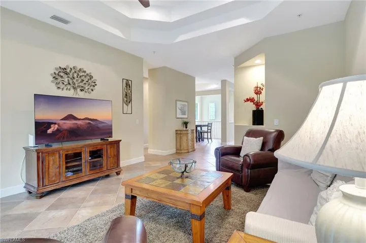 Living room featuring a raised ceiling and tile floors