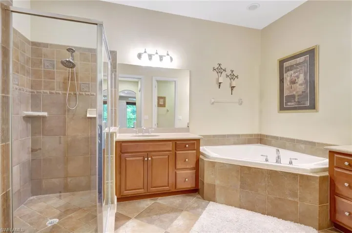 Bathroom with vanity, tile floors, and plus walk in shower