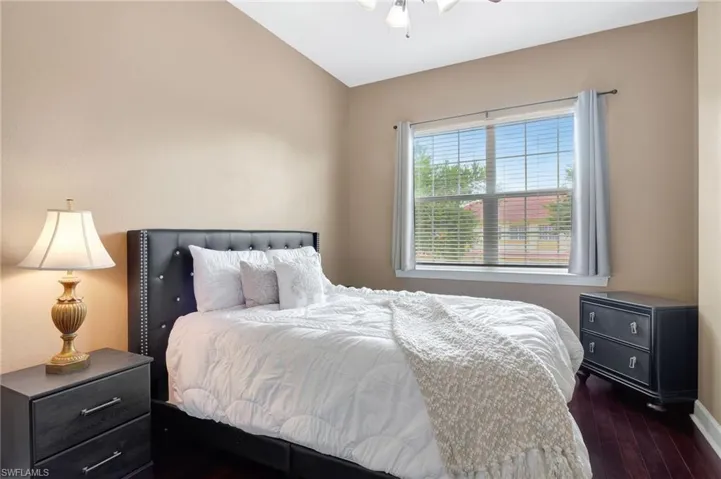 Bedroom featuring vaulted ceiling, dark hardwood / wood-style flooring, and ceiling fan