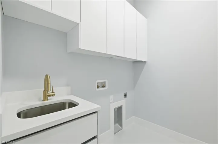 Washroom featuring hookup for an electric dryer, washer hookup, and cabinet space