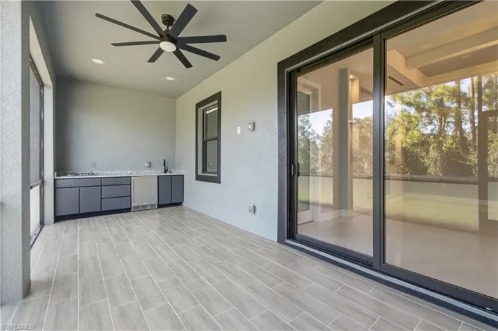 View of patio with a ceiling fan and an outdoor kitchen