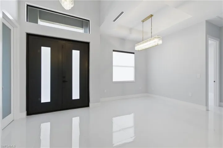 Foyer entrance with a chandelier and a raised ceiling