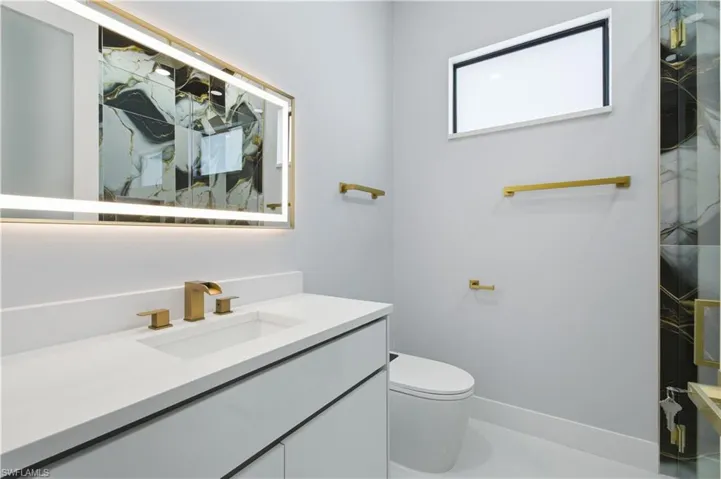 Full bathroom featuring vanity and a marble finish shower