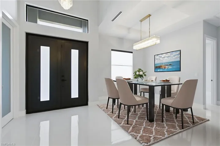 Dining room featuring a chandelier, a tray ceiling, and french doors