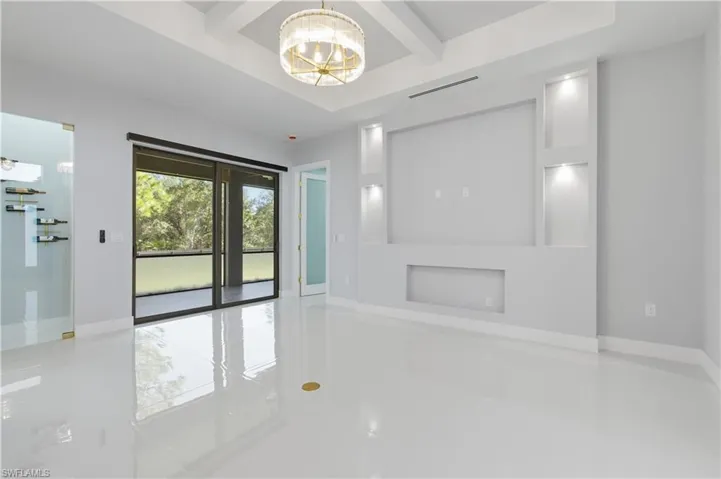 Unfurnished living room with beamed ceiling, a chandelier, and light tile patterned floors