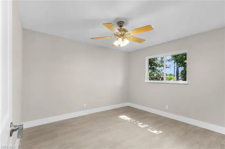 Empty room featuring light wood-style flooring and ceiling fan