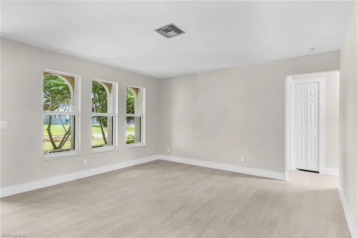 Spare room featuring light wood-style flooring and baseboards
