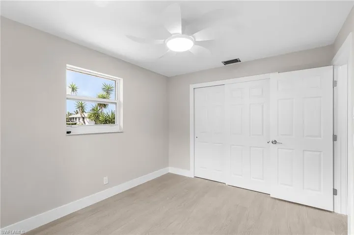 Unfurnished bedroom featuring light wood-style flooring, a closet, and a ceiling fan
