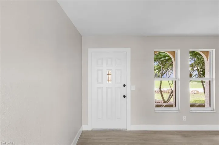 Entryway featuring baseboards and wood finished floors