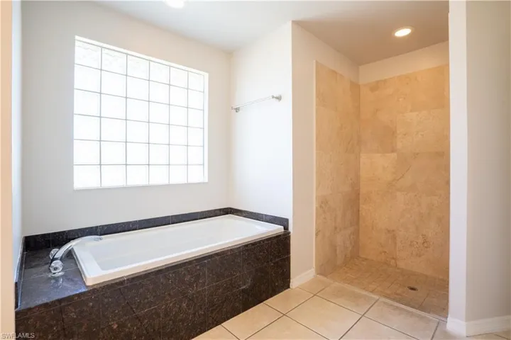 Bathroom with a garden tub, tile patterned floors, tiled shower, and recessed lighting