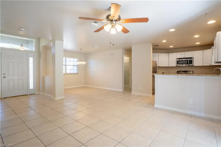 Kitchen featuring white cabinetry, light tile patterned floors, a ceiling fan, appliances with stainless steel finishes, and recessed lighting