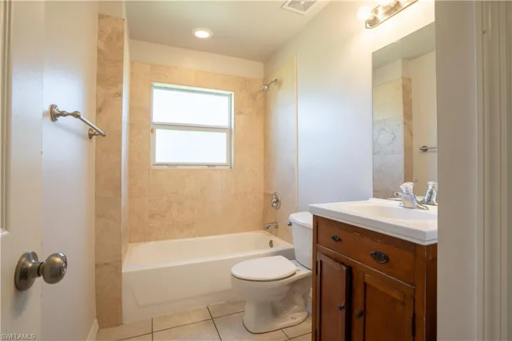 Full bathroom featuring vanity, light tile patterned floors, and shower / bath combination