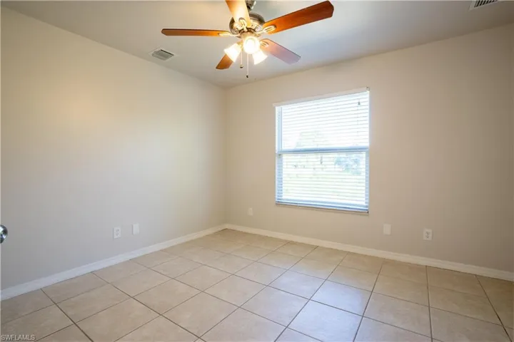 Spare room with light tile patterned floors and a ceiling fan