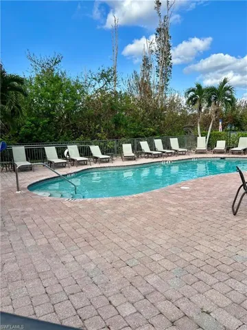 Community pool featuring a patio and fence