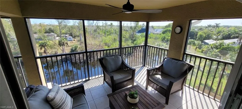 Sunroom featuring a ceiling fan and a water view