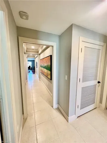 Hallway with light tile patterned floors and baseboards
