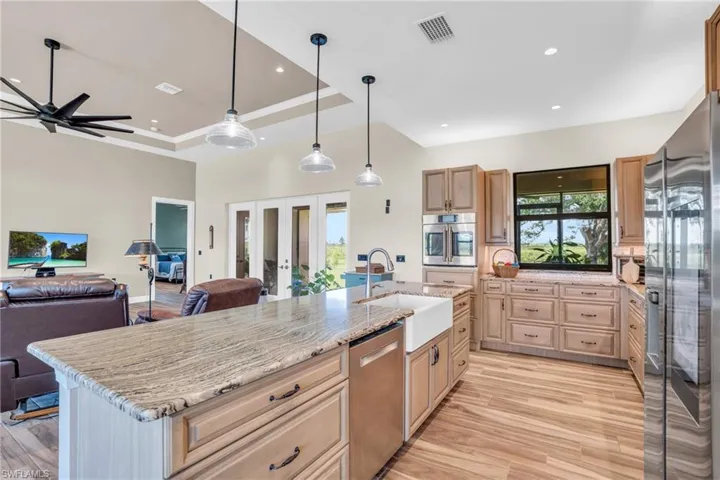 Kitchen with wall chimney exhaust hood, a center island, a kitchen breakfast bar, and light hardwood / wood-style floors