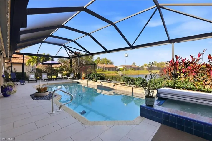 Swimming pool featuring a sunroom, a patio area, a lanai, a residential view, and a hot tub