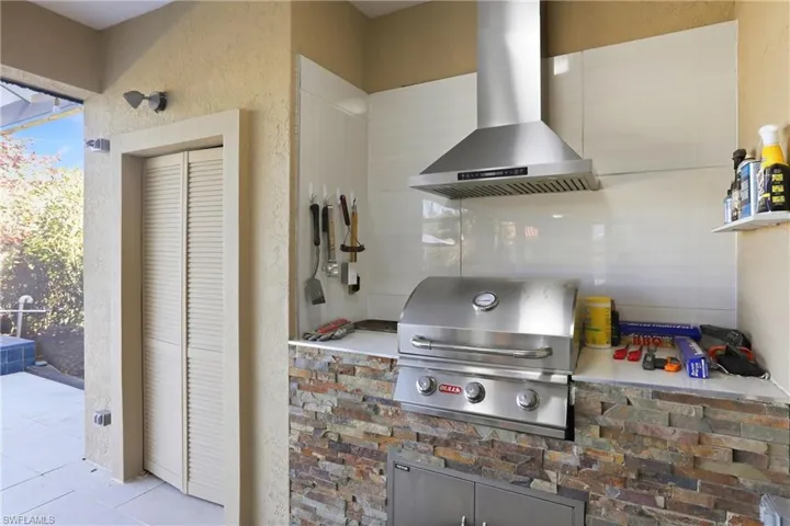 Kitchen with wall chimney range hood and a textured wall