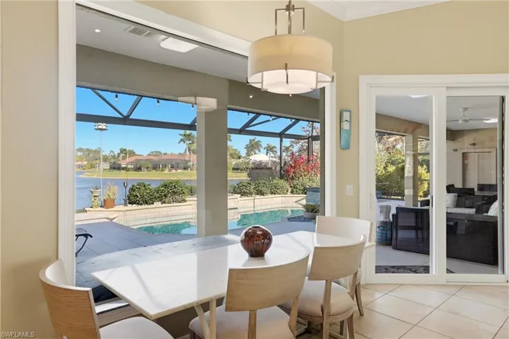Dining area featuring a sunroom, light tile patterned floors, and a water view