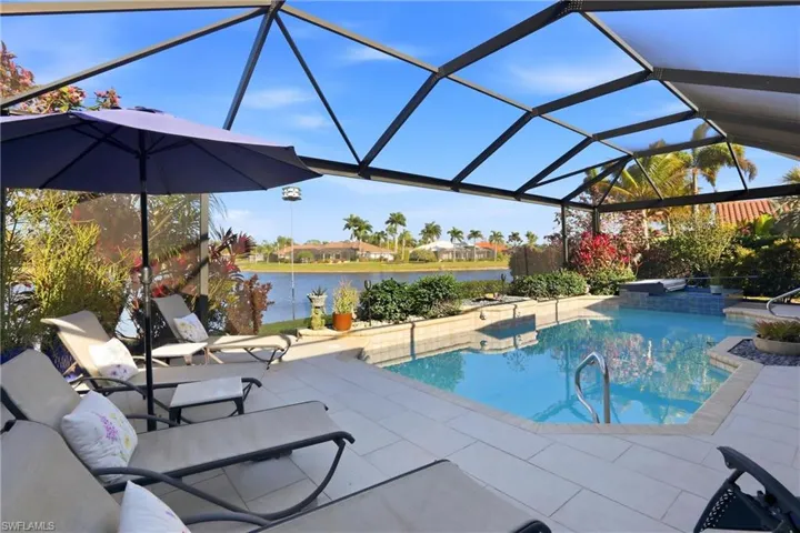 Swimming pool featuring a lanai, a patio area, a sunroom, and a water view
