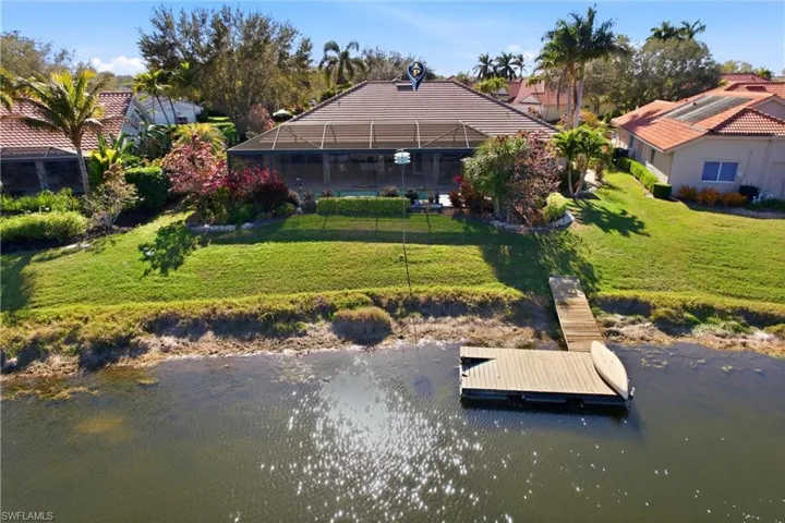 Dock area featuring a water view, a yard, a lanai, and a sunroom