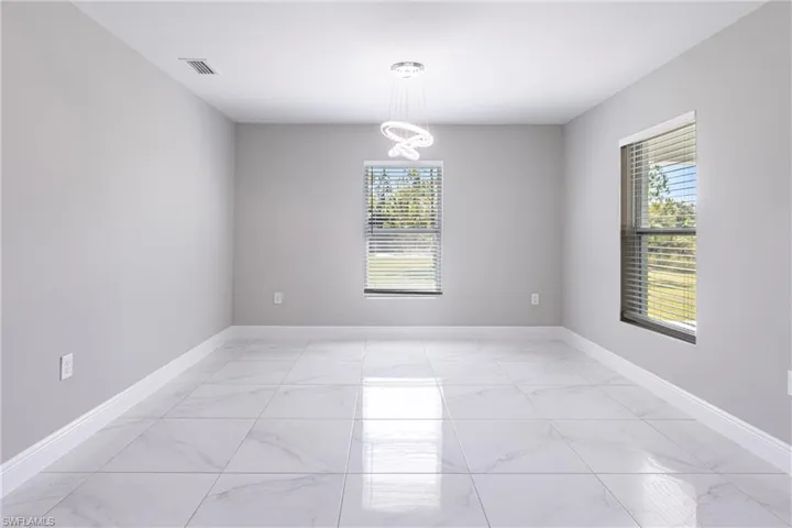 Spare room featuring light marble finish flooring and healthy amount of natural light
