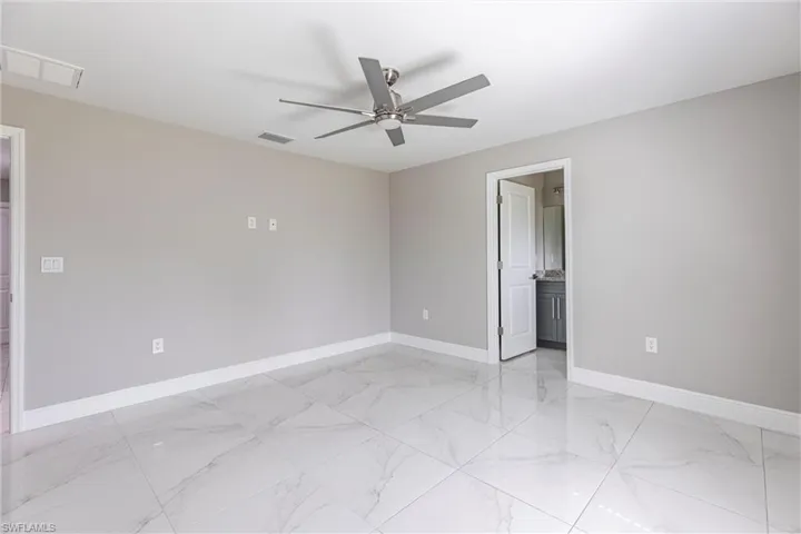 Empty room with light marble finish flooring and a ceiling fan