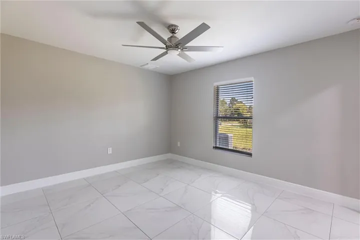 Spare room featuring light marble finish flooring and baseboards