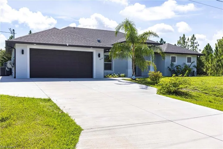 View of front of home featuring stucco siding, a shingled roof, concrete driveway, and a garage