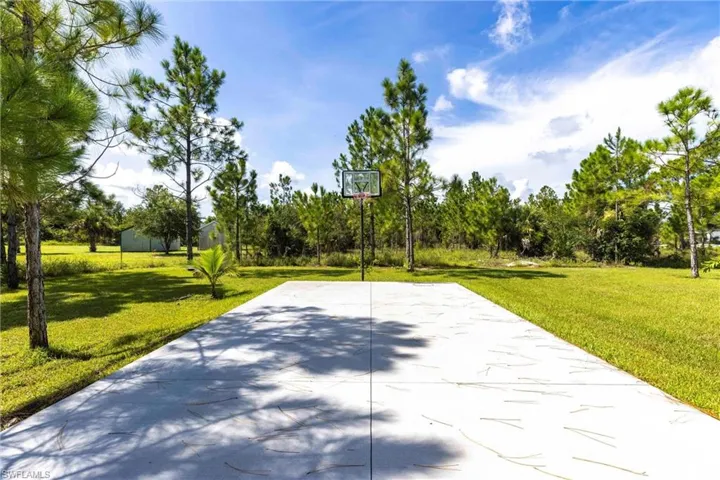 View of basketball court with a lawn and community basketball court
