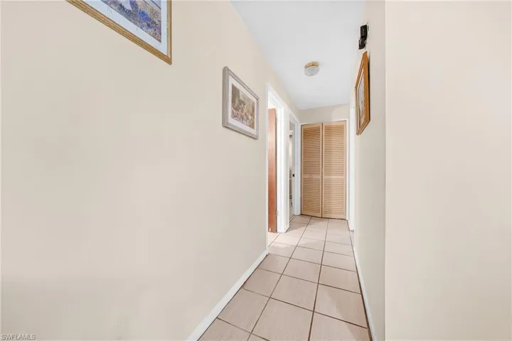 Hall with light tile patterned floors and baseboards