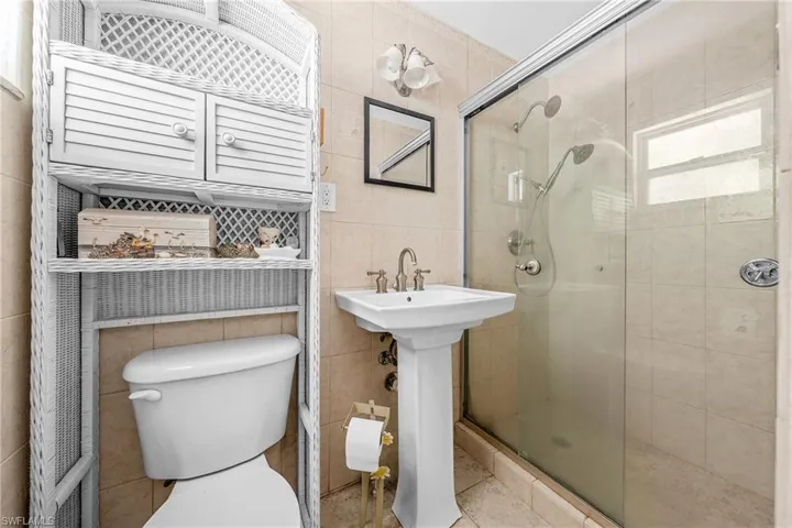 Full bath featuring tile walls, a shower stall, and tile patterned floors