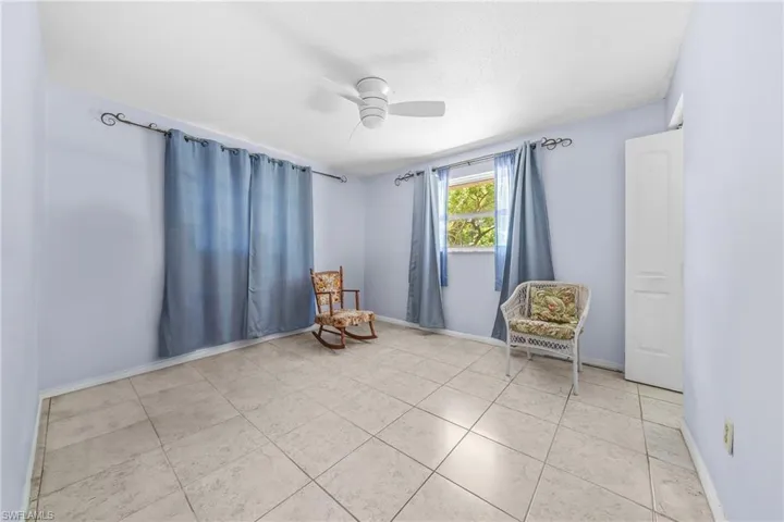 Living area featuring ceiling fan and light tile patterned flooring