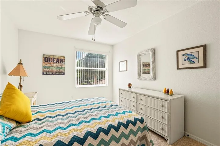 Carpeted bedroom featuring ceiling fan
