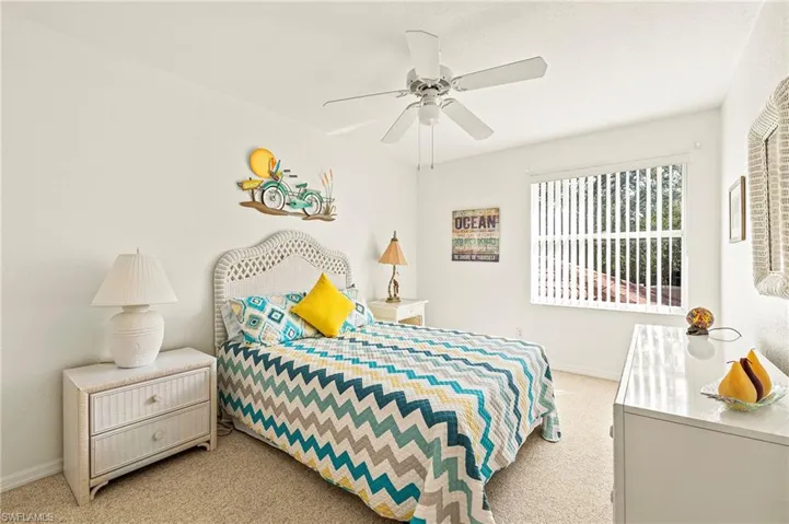 Carpeted bedroom featuring ceiling fan