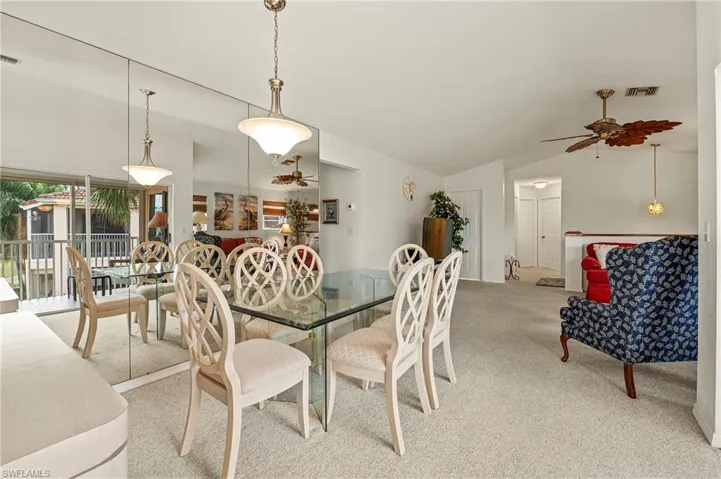 Dining room featuring carpet, ceiling fan, and vaulted ceiling