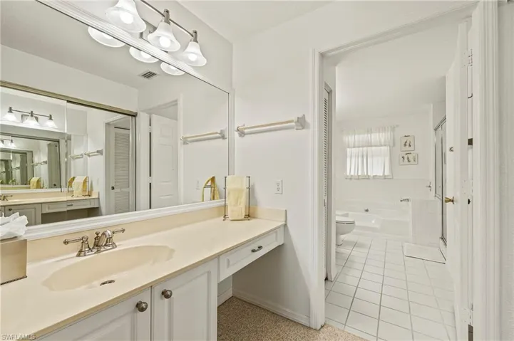 Full bathroom featuring tile patterned floors, separate shower and tub, vanity, and toilet