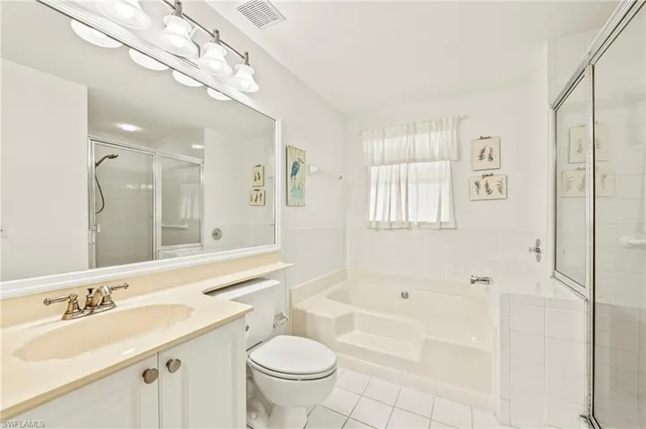 Full bathroom with tile patterned flooring, vanity, toilet, and plus walk in shower